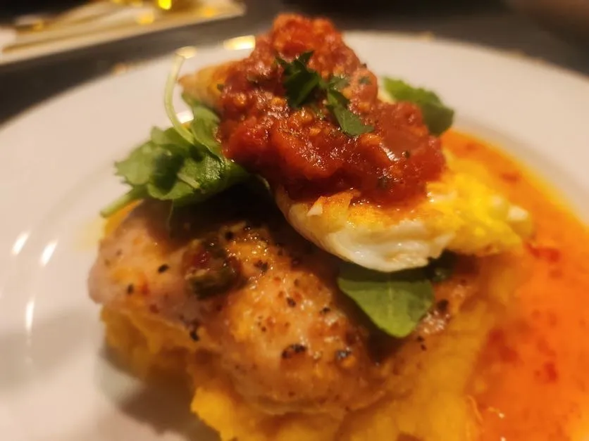 Beautifully plated chicken with fresh herbs and tomato relish